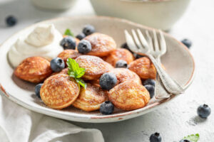 Holy-Crepe-Homemade-Pancake-Ice-Cream-image-11-plate-of-dutch-poffertjes-dusted-in-powdered-sugar-Frosted-Fusions