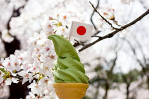 Homemade Matcha Ice Cream Recipe – A Taste Of Japan image 3 ice cream waffle cones filled with green matcha soft serve with Japanese Flag and blossom tree Frosted Fusions
