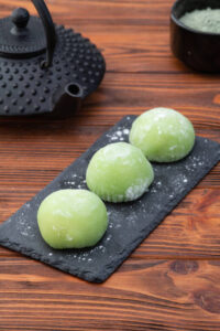 Homemade Matcha Ice Cream Recipe – A Taste Of Japan image 4 matcha mochi lined up on black chalk board with tea pot in the background Frosted Fusions