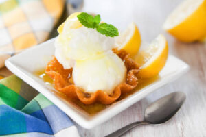 Spring-Inspired Ice Cream Recipes To Celebrate Mother’s Day image 4 lemon ice cream with fresh lemons in a waffle bowl Frosted fusions