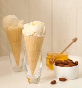 Honey, Yoghurt & Toasted Almond Ice Cream – A Naturally Sweet Scoop image 2 bowl of honey ice cream with a honey and fresh almonds in the baclground Frosted Fusions