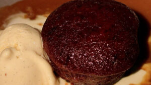 Sticky Toffee Pudding Ice Cream – A Delicious Fusion Of Flavours image 4 close up of rich sticky toffee pudding next to a scoop of ice cream Frosted Fusions