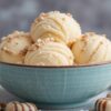 Homemade-Humbug-ice-cream-recipe-featured-image-637x1920w-bowl-of-ice-cream-with-a-glass-jar-of-toffee-sauce-and-humbug-sweets-scattered-around-Frosted-Fusions
