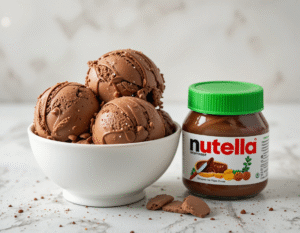 Nutellas-Gone-Vegan-–-Try-Our-Healthy-Easy-Recipes-That-Youll-Love-Image-3 white bowl of nutella ice cream scoops with a jar of vegan nutella to the side Frosted-Fusions