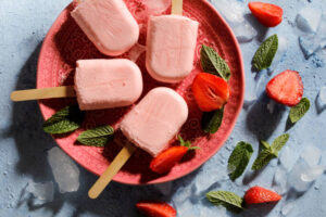 Fun-Easy-Homemade-Ice-Lollies-Popsicles-—-The-Perfect-Summer-Treat-image-4-top-view-of-strawberry-yoghurt-lollies-with-fresh-strawberries-Frosted-Fusions