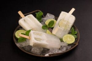 A-Dairy-Free-Coconut-Mojito-Cocktail-Sorbet-With-Mocktail-Options-image-2-Mojito-Sorbet ice lolloes in brown dish with-fresh-mint-leaves and limes-Frosted-Fusions