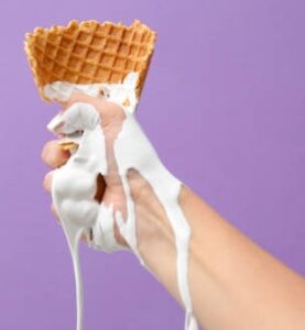 How-To-Stop-Homemade-Ice-Cream-From-Melting-Too-Fast-image-2-person-holding-an-ice-cream-waffle-cone-ice-cream-melting-down-their-hand-and-arm-Frosted-Fusions